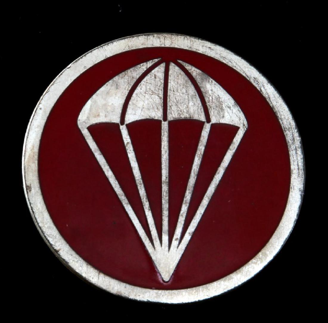 WWII US ARMY AIRBORNE PARATROOPER CAP BADGE: Measures 1 3/4 inches in diameter. Has a thin vertical English style pinback. Nickel construction with enamel.