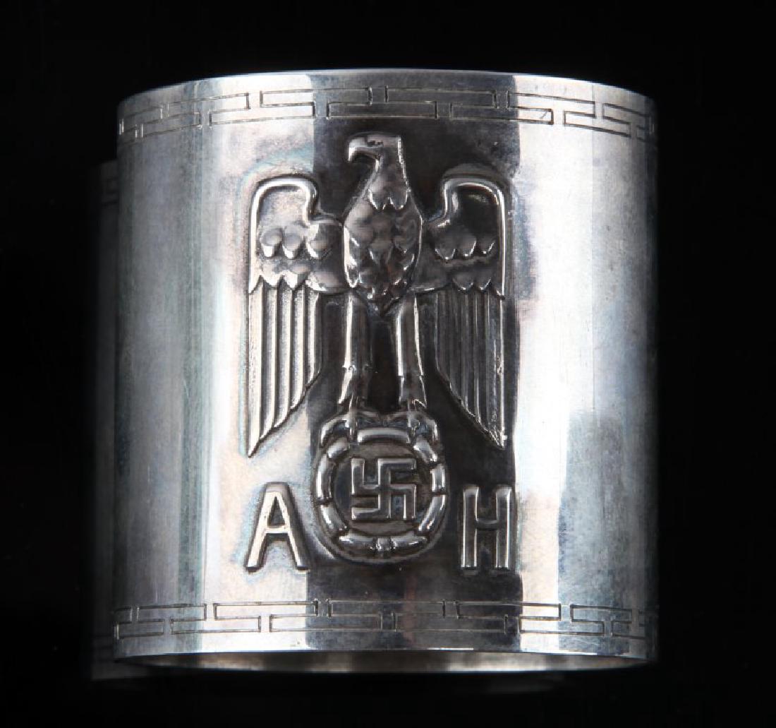 WWII GERMAN THIRD REICH SILVER HITLER NAPKIN RING: Measures 1 3/4 inches long by 1 11/16 inches in diameter. The front shows an NSDAP Reichsadler with the letters 'AH' below. The reverse is maker makred 'Bruckmann' and has 4 hallmarks; a half moon, a