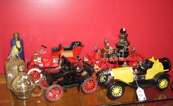 JIM BEAM DECANTERS MODEL A FORD FIRE ENGINE & MORE : Jim Beam Decanter Lot, 7 decanters total, primarily from the 1970's, most are sealed with contents. Included in this lot is a Mississippi Fire Engine Decanter, 1904 Curved Dash Oldsmobile Decanter (1s