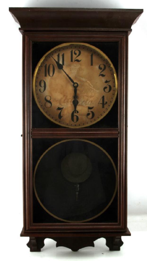 VINTAGE COCA COLA ADVERTISING PENDULUM CLOCK: Drink Coca Cola in its classic script is set on the face of this wall mounted Pendulum clock, it is legible despite the fading of its red color. Measurements are 34x18x4 inches. Wood back plate will n
