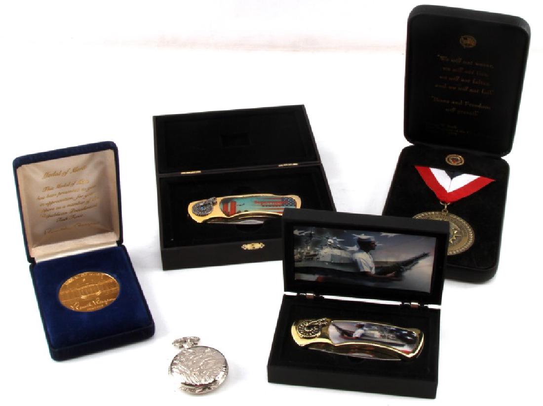 US PATRIOTIC KNIFE MEDAL AND POCKET WATCH LOT OF 5: Lot of 5 items, 2 knives in display boxes, one commemorating the September 11th attacks, the other displaying a Navy cruiser and sailor with machine gun. Also two medals, one a Medal of Merit presente