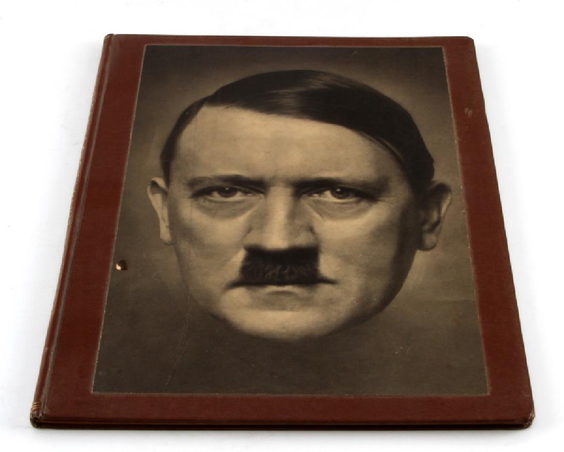ADOLF HITLER EIN MANN UND SEIN VOLK BOOK: 'Adolf Hitler Ein Mann Und Sein Volk' hardcover book with newspaper textured pages. Heavy foxing. Small nick to cover. Possible water damage. (Inv #100-128 bin)