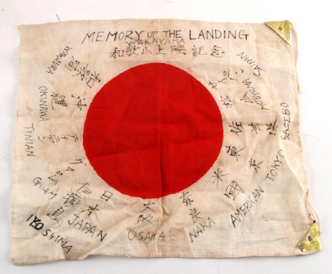 MEMORY OF THE LANDING SMALL JAPANESE MEATBALL FLAG: Small Japanese "meatball" flag. Reads "Memory of the Landing" across the top accompanied by different locations and Japanese text. Light soiling. Measures 11"x14". VG condition.