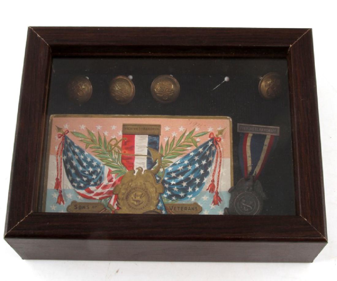 SONS OF VETERANS POST CIVIL WAR MEDAL DISPLAY: Display of a medal for a member of the Sons of Veterans organization and a post card dated to 1911 from the same group, as well as a display of 6 GAR buttons. In good condition, with the ribbon of the