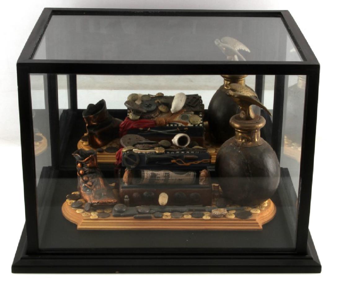 UNITED STATES CIVIL WAR ERA THEMED GLASS DIORAMA: Measures 16 inches long by 12 inches wide by 12 inches tall in glass display case. Wood base with coins and buttons attached. There is a shoe, eagle and a rifle around a treasure chest. The chest has