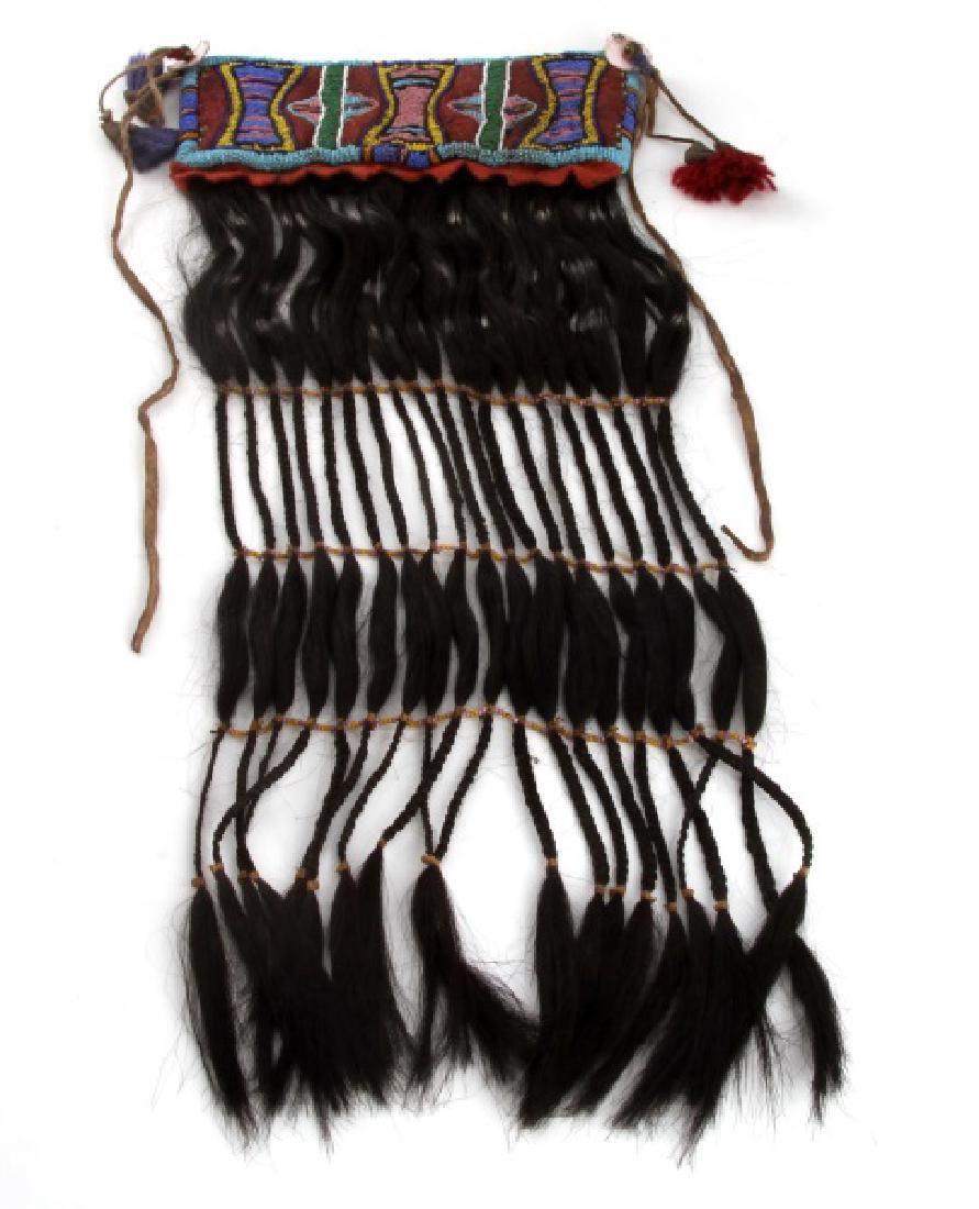 BLACKFOOT NATIVE AMERICAN WAR SHIRT BEADED PATCH: Early 1900's Black foot hand beaded war shirt adornment with horse hair fringe and trade felt and dew claw tassels. Total measurements are 22 by 10 inches. In very good condition with beadwork intact.
