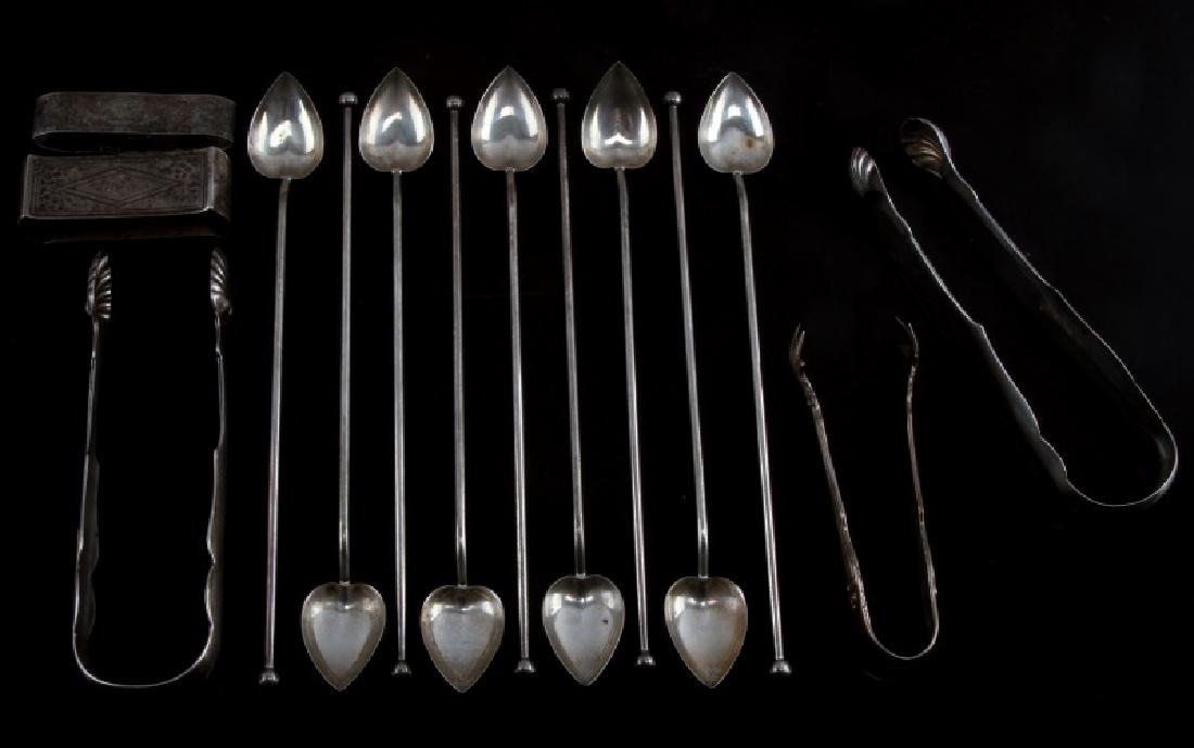 9 COIN SILVER COFFEE SPOONS 3 TONGS 2 NAPKIN RINGS: Lot of coin silver silverware. Includes 9 heart shaped coffee spoons that measure 8 1/4" in length, 3 tongs, and 2 napkin rings. Light tarnishing on all pieces with the heaviest present on the napkin 