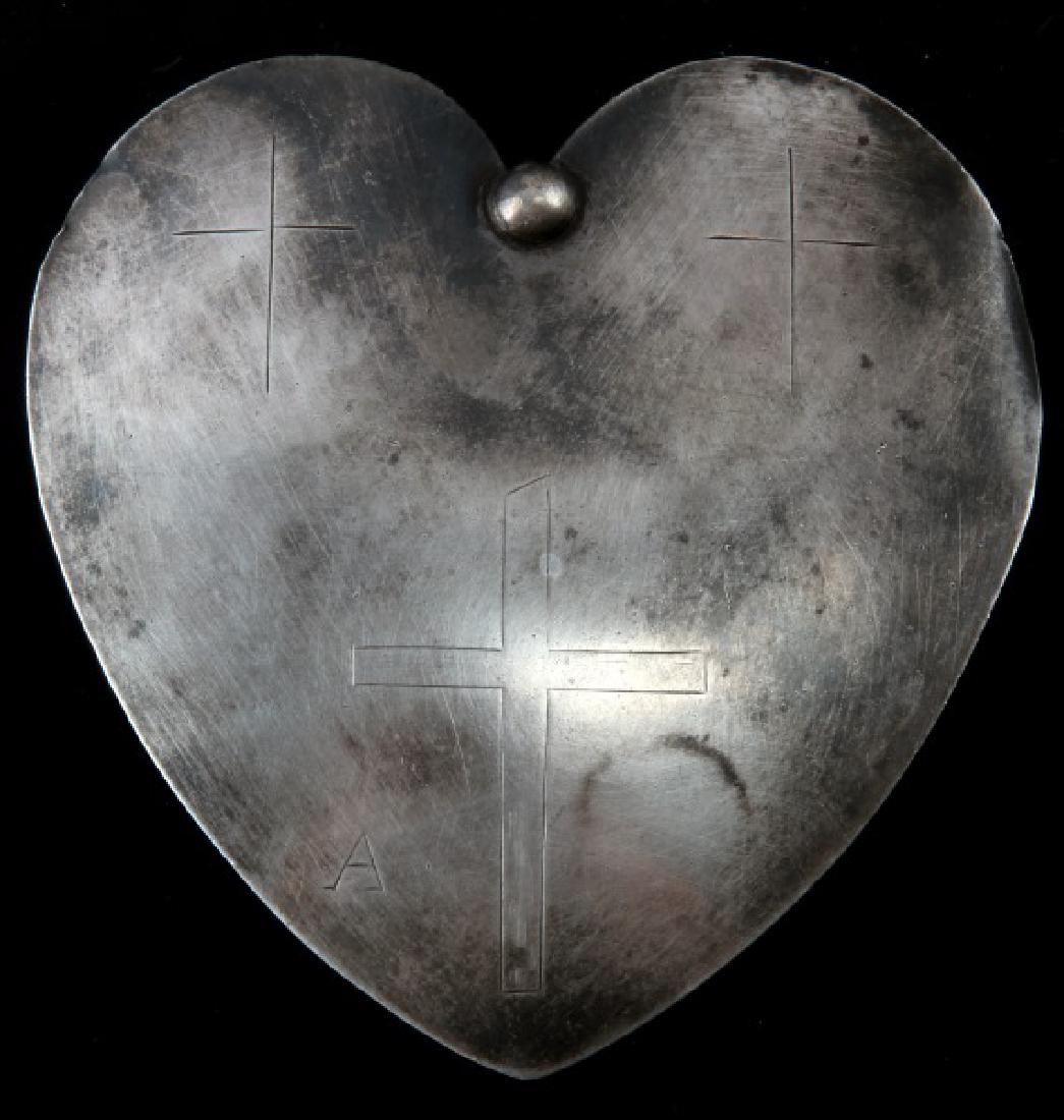 HEART SHAPE ENGRAVED NATIVE AMERICAN TRADE PENDANT: Heart Shaped Native American Fur Trade Pendant with one central pin with a loop to allow for hanging. Pendant is engraved with a 3 frontal crosses with the center cross being the focal point of the en