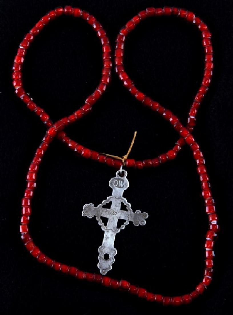 ANTIQUE NATIVE AMERICAN FUR TRADE SILVER CROSS: Silver Latin cross from the fur trade with Native Americans. DW maker's mark at the top of the cross. It is 2 1/2 inches in length and has a red Venetian bead necklace that is original to the same tim