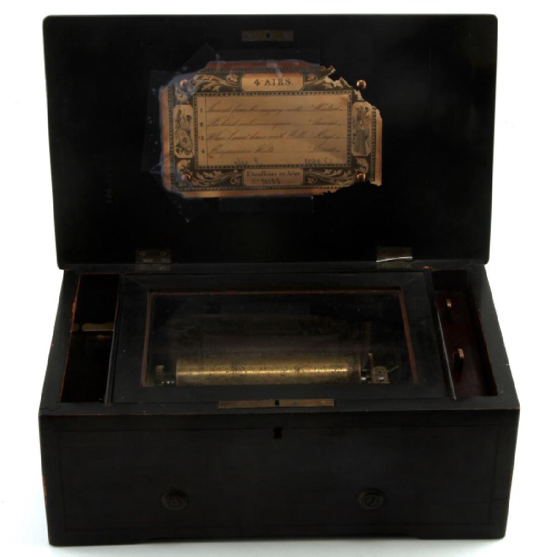 ANTIQUE SWISS BRASS CYLINDER INLAY MUSIC BOX: Circa 1890 -1910, 5" inch brass cylinder playing 4 airs, with the original label numbered 10128. Harp attachment and glass top are intact. Top lid finely inlaid with a violin and horn and the front si