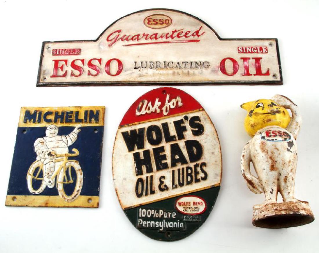 VINTAGE CAST IRON ADVERTISING SIGN & DISPLAY LOT: Lot of 4 includes 3 signs: Michelin Man on a bicycle 20x17cm, Wolf's Head Oil & Lube oval 29x20cm and Esso Lubricating Oil48x18cm. Along with signs is the Esso Mr. Drip, 9.5inches in height, cast iron