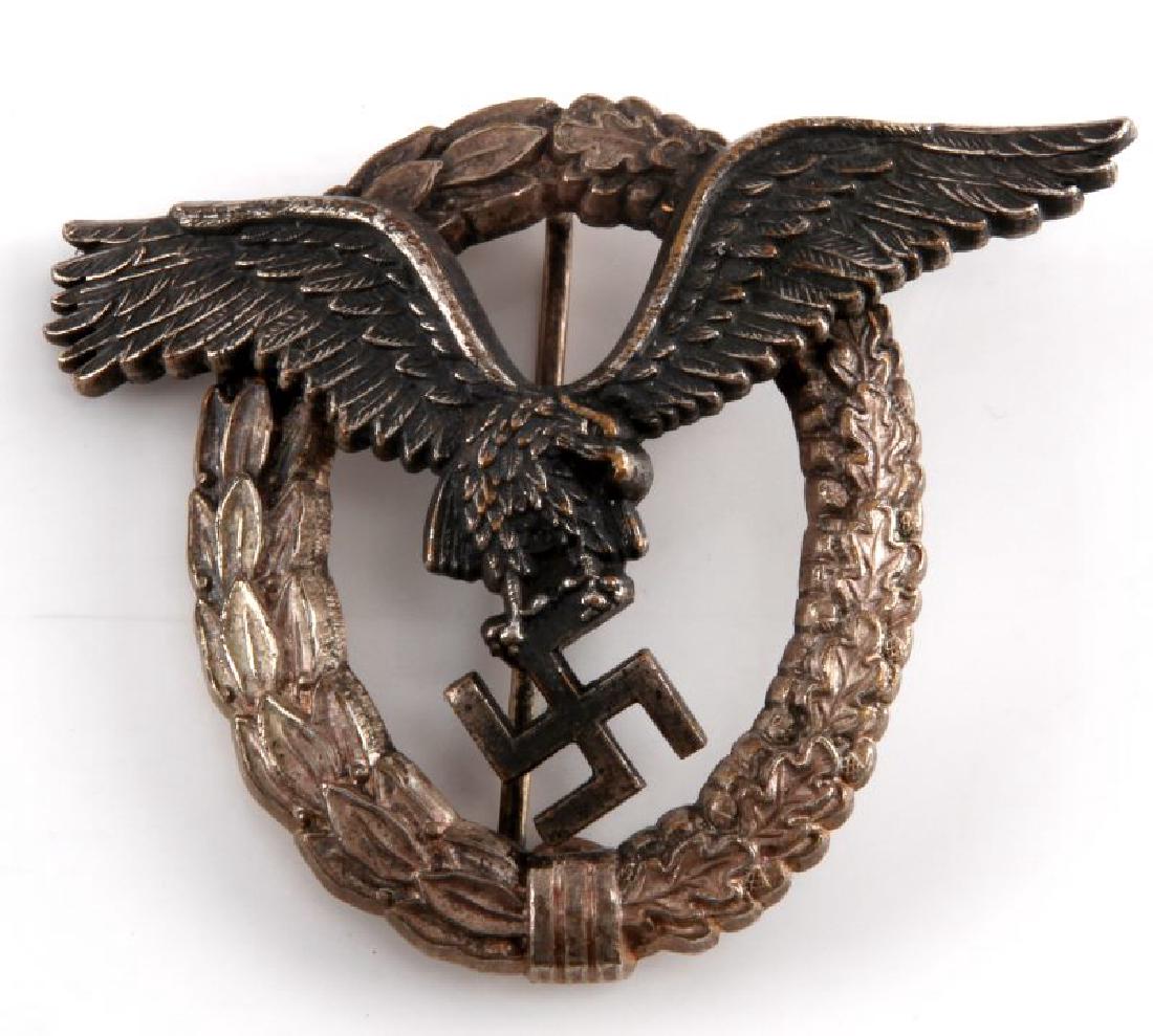 GERMAN WWII LUFTWAFFE PILOT BADGE JUNKER: German WWII Luftwaffe pilot badge. C.E. Junker Berlin SW68 maker stamp on reverse. Good patina. "C" hook bent shut. Thin vertical "T" bar style back pin. Crisp detail. VG condition.