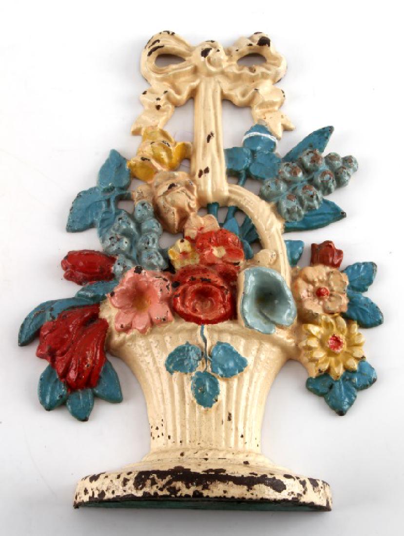 ANTIQUE CAST IRON FLOWER DOOR STOP: Brightly colored, antique cast iron flower door stop. Minor paint loss and oxidation. Measures 10 3/4" tall and 8" in max width. Stamped on reverse "189". Overall VG condition.