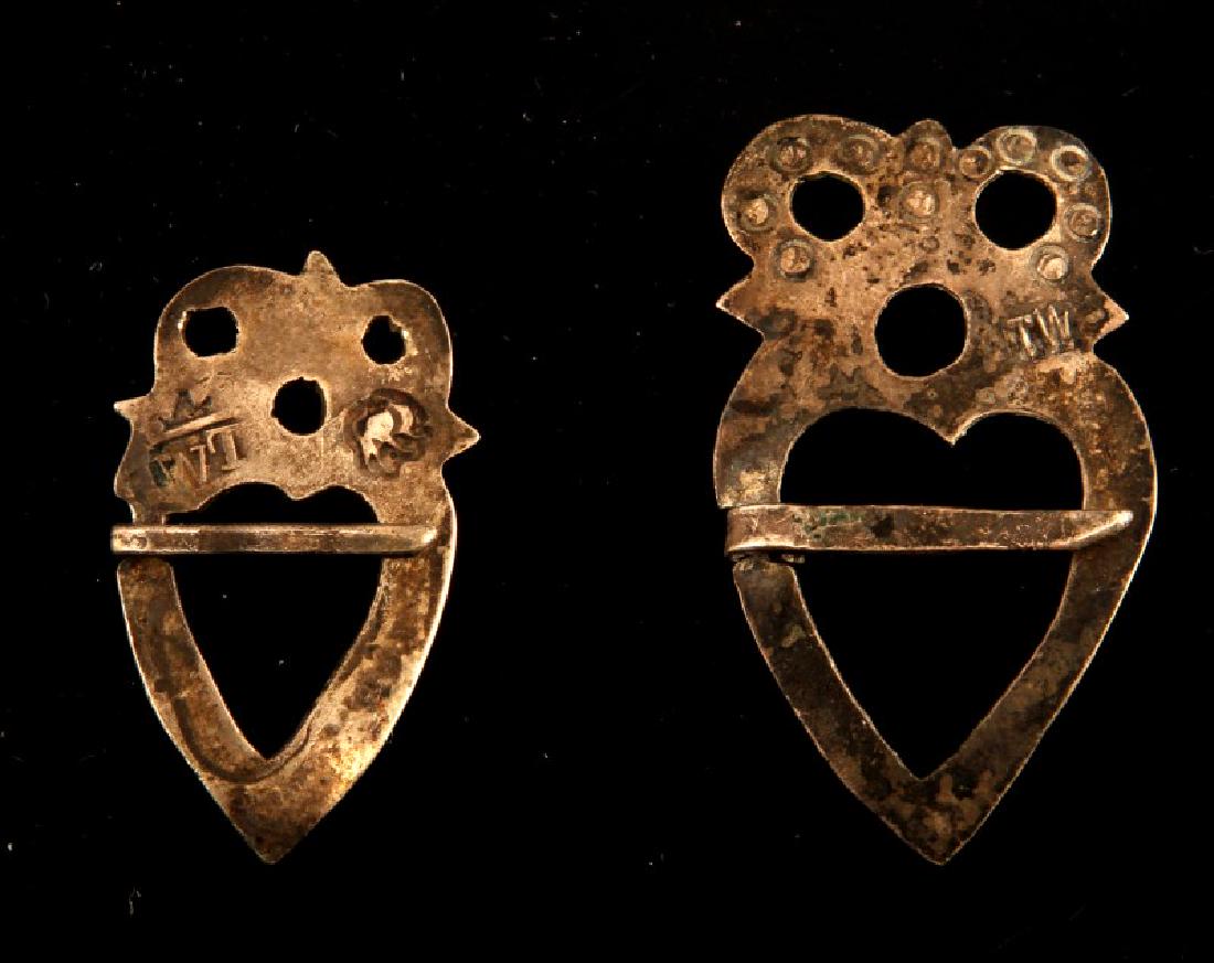 PAIR OF MARKED NATIVE AMERICAN FUR TRADE BROOCHES: Pair of Native American Silver fur trade era silver brooches both fashioned in the shape of an owl with a central heart shaped gap. Both pins bear individual manufacturer's marks, the first brooch is 