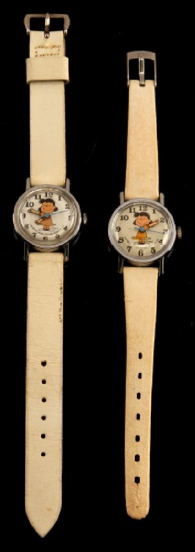 2 ANTIQUE LUCY PEANUTS 1952 WRIST WATCH LOT: Lot of TWO (2). Both are cleaned & oiled. One (1) is in very good running condition, one (1) seems to work sporadically. Off-white leather straps which appear to be kid sized. Dated 1952.