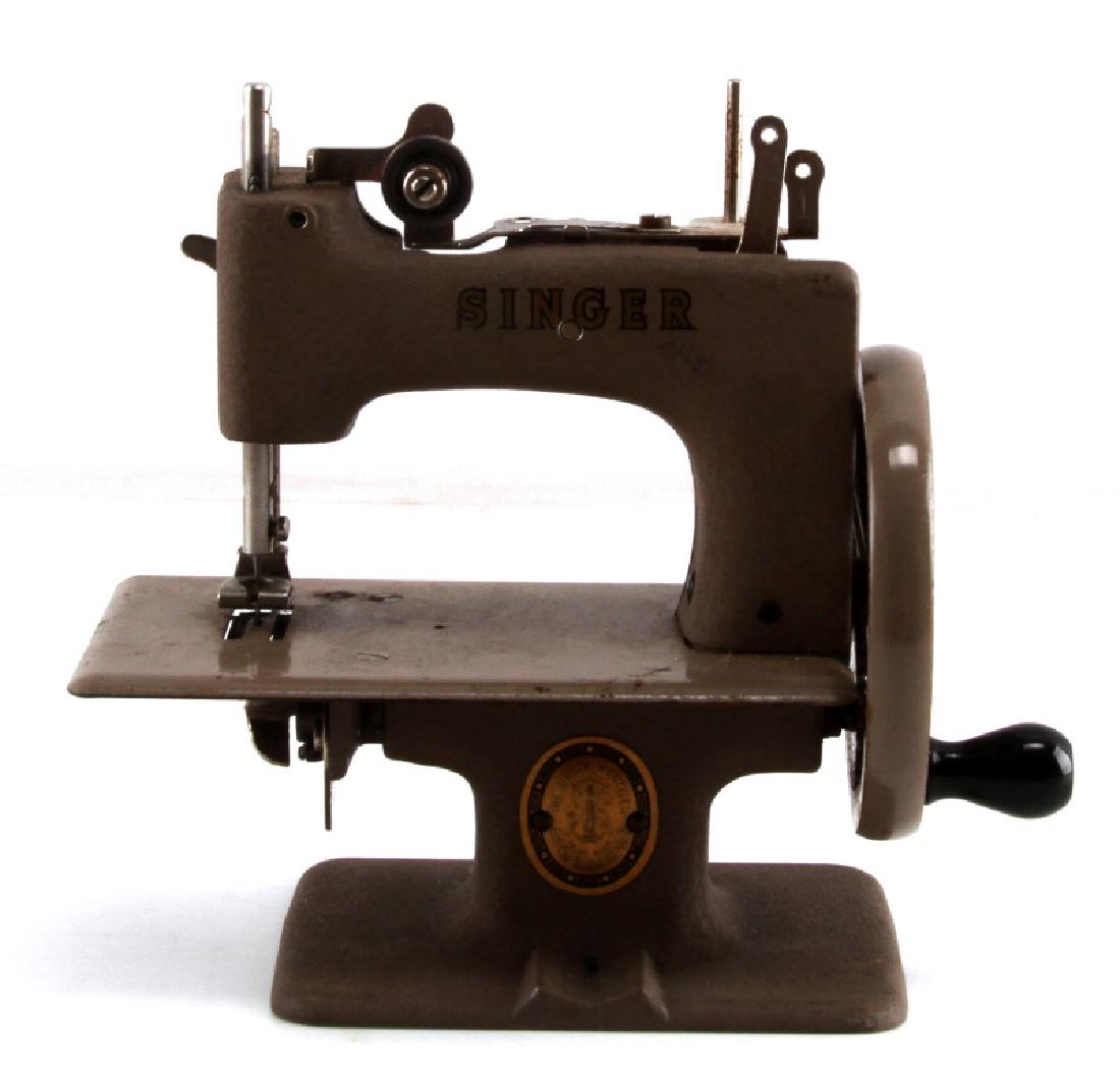 VINTAGE CHILDS TOY SINGER SEWING MACHINE: In good condition with minor surface rust particularly on the undercarriage and bobbin assembly. Hand cranked and appears to be in working condition.