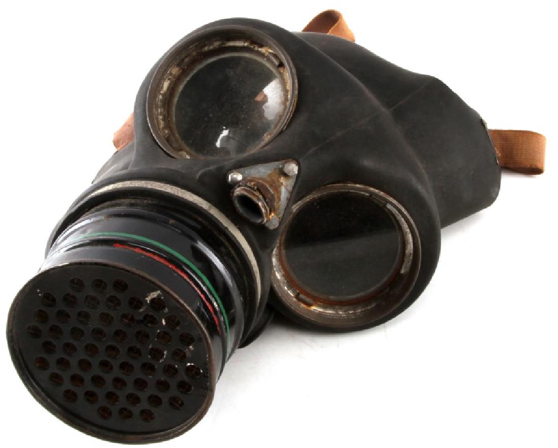 POST WWII BRITISH MADE GAS MASK W CANISTER & STRAP: Post-WWII era British made rubber Gas mask with filter original fog lenses and original filter canister, which bears some paint loss and corrosion with makers markings on the obverse of base rubber fa