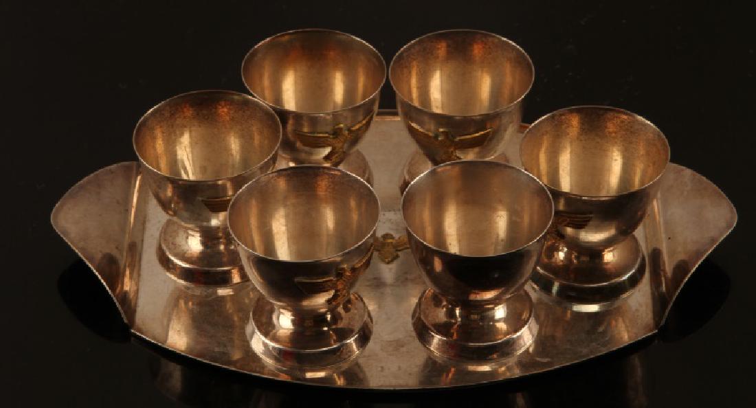 6 GERMAN WWII 3RD REICH SCHNAPPS CUP & TRAY LOT: From Heer officer's canteen. Oval tray has raised German eagle insignia and measures 8 1/2 x 5 3/8 inches. Cups stand 1 3/4 inch each. Some scratches and normal age wear. Good condition. Unauthenticat