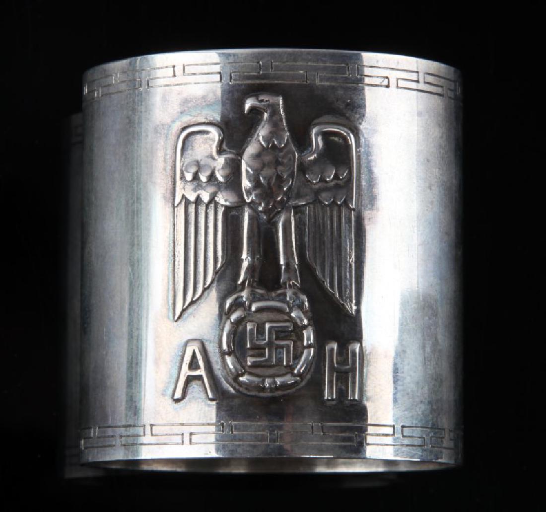WWII GERMAN THIRD REICH SILVER HITLER NAPKIN RING: Measures 1 3/4 inches long by 1 11/16 inches in diameter. The front shows an NSDAP Reichsadler with the letters 'AH' below. The reverse is maker marked 'Bruckmann' and has 4 hallmarks; a half moon, a 