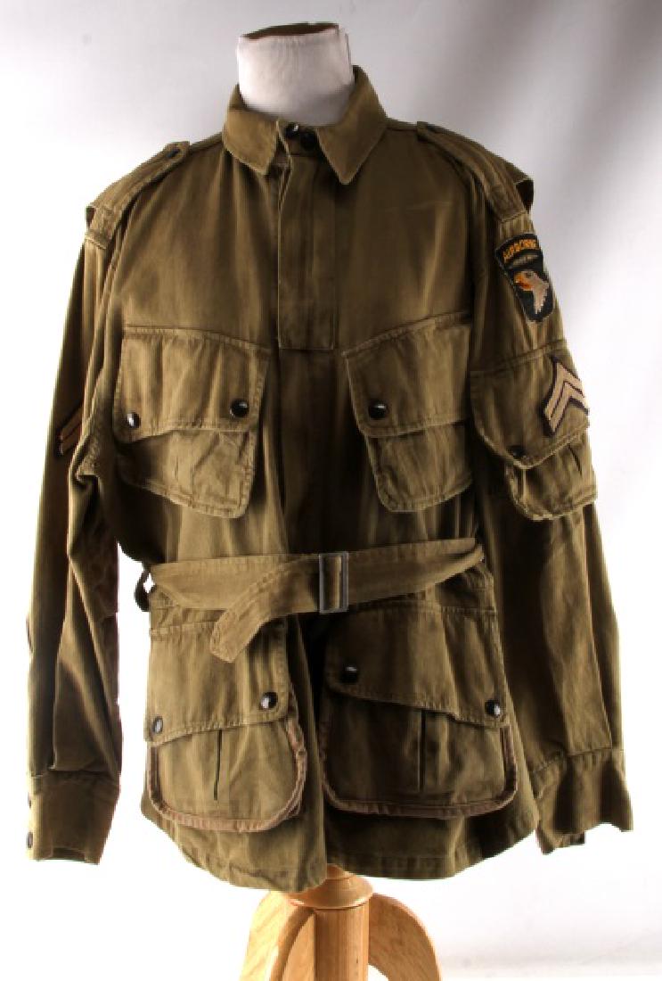 WWII 101ST AIRBORNE PARATROOPER M42 JUMP JACKET: There is a 101st Airborne Screaming Eagle patch machine sewn onto upper left sleeve. Also has corporal's chevrons sewn on each arm. The body is a beige cotton material. Both zippers are marked 'Talon'