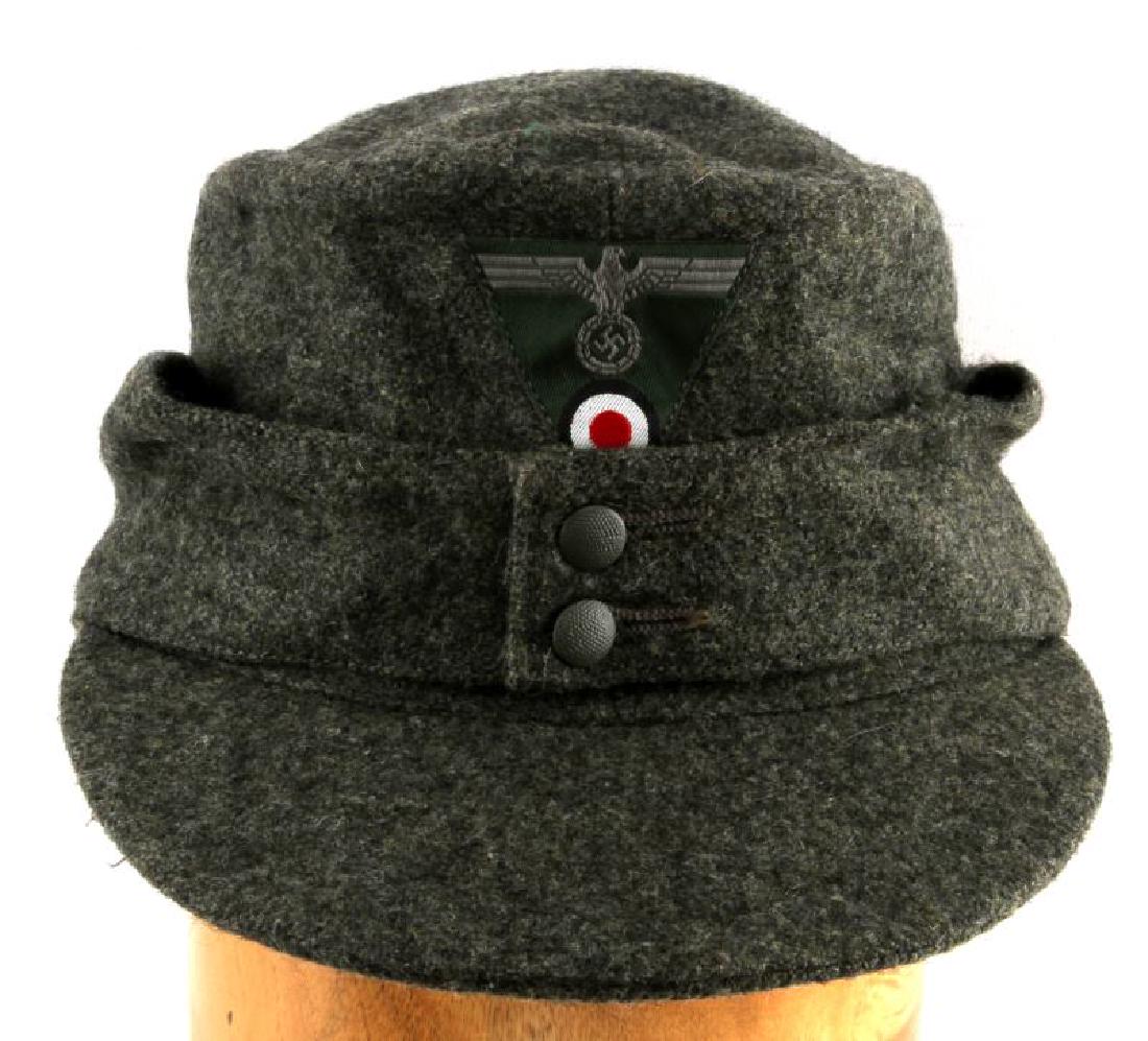 WWII GERMAN THIRD REICH WEHRMACHT M43 FIELD CAP: M43 field cap cut from grey-green wool. Has a single Reichsadler and roundel triangular patch on the front. Marked "59" on the inside. In very good condition. Does not fluoresce under blacklight.