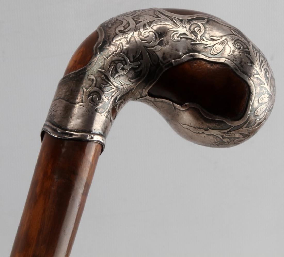 KNOBBY WOOD WALKING STICK CANE SILVER OVERLAY: Vintage knobby wood cane with tooled floral design silver to handle. Initials "MG" to front neck of silver. Original metal ferrule tip. Measures 34.5 inches long. General wear and small hairline crack