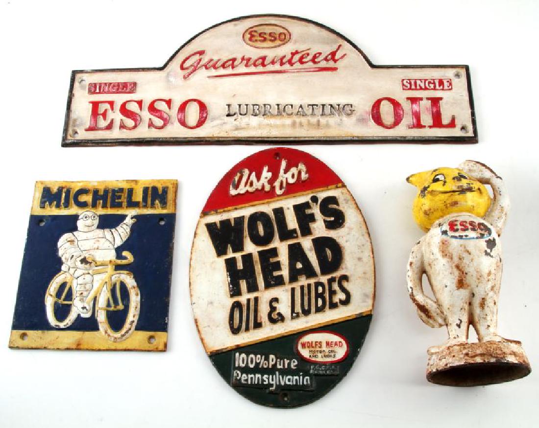 VINTAGE CAST IRON ADVERTISING SIGN & DISPLAY LOT: Lot of 4 includes 3 signs: Michelin Man on a bicycle 20x17cm, Wolf's Head Oil & Lube oval 29x20cm and Esso Lubricating Oil48x18cm. Along with signs is the Esso Mr. Drip, 9.5inches in height, cast iron