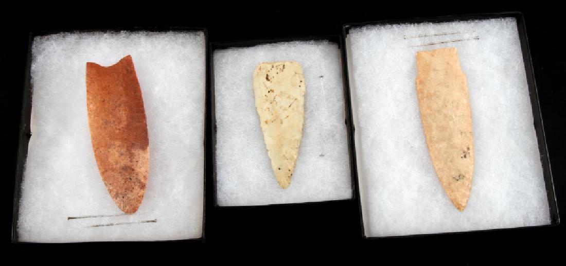 NATIVE AMERICAN PALEO TO WOODLAND ARROWHEAD LOT: Wheeler excurvate arrowhead, formed from a ruddy chert, with flutes chipped into the lower third of the blade and a horizontal transverse flaking pattern. The base is strongly concave, and the arrowhe