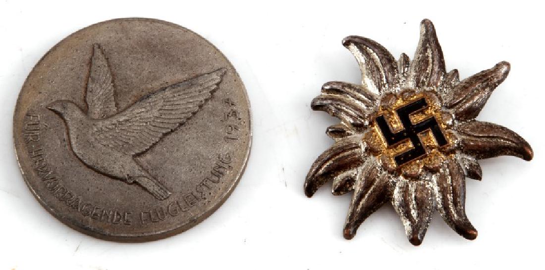 GERMAN EDELWEISS VISOR INSIGNIA & TABLE AWARD: German WWII Mountain Troop Edelweiss visor cap insignia. Measurse 1 1/2" wide by 1 1/2" tal. Reverse is RZM stamped with "M1/3" Nickel construction with brass highlights. Black painted swastika in cen