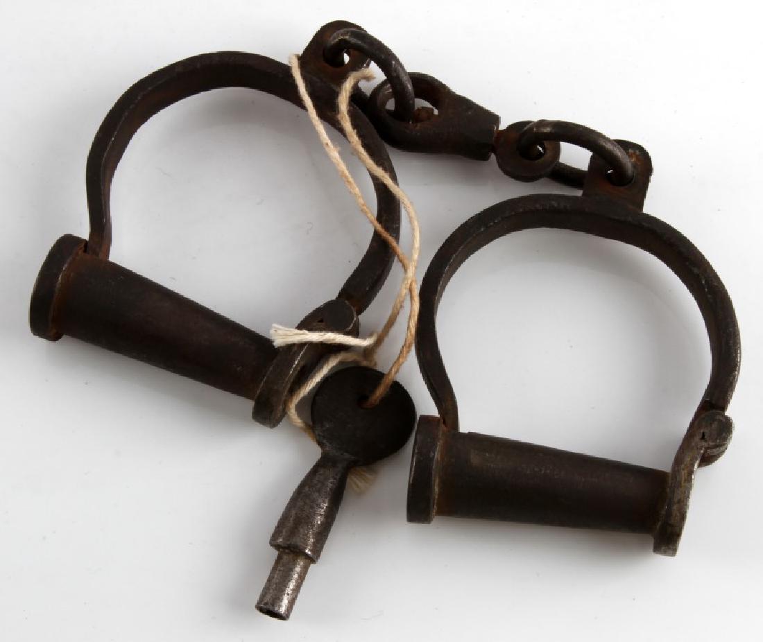 ANTIQUE SCREW LOCK COLORADO PRISON HANDCUFF LOT: One set of handcuffs with screw locks. One of the manacles has a brass plate which reads 'Colorado Territorial Prison Canon City, Col.'. The opposite manacle is marked '2 3/4' and '191'. The key is ma