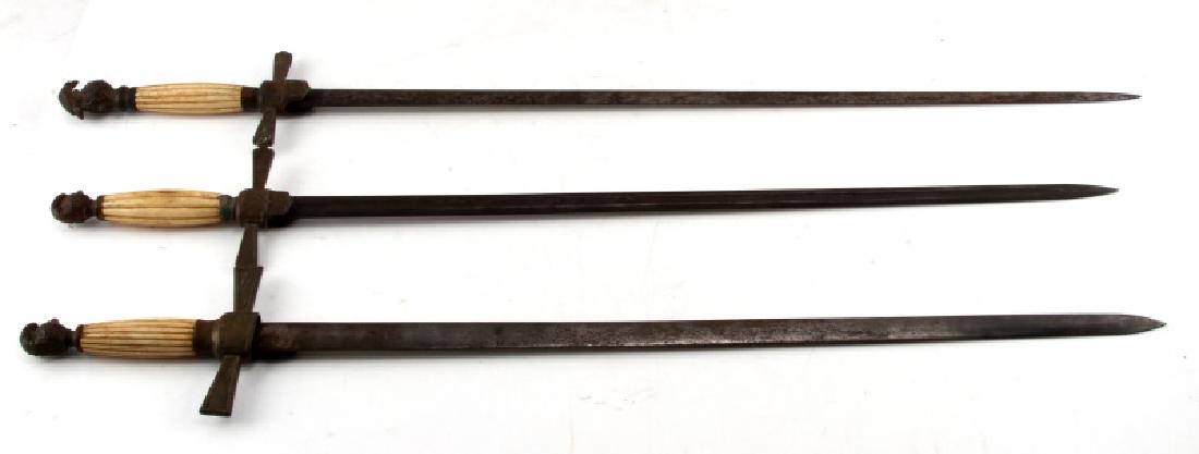 ANTIQUE US FRATERNAL OR MILITIA SWORD LOT OF THREE: Lot contains three swords, all of which are cruciform, have a bone hilt, and a pommel which is shaped like the helm of a knight. Belong to either an unknown fraternal organization or a militia force. 