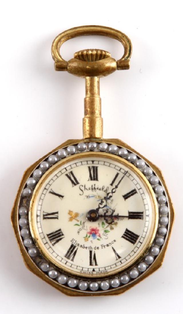SHEFFIELD ELISABETH DE FRANCE POCKET WATCH: Pendant necklace/pocket watch. Great, unique design. Missing a couple of beads around edge. Approximate measurements: 2 x 1 1/4 inches. Some light wear present. Watch in very good working and cosmetic
