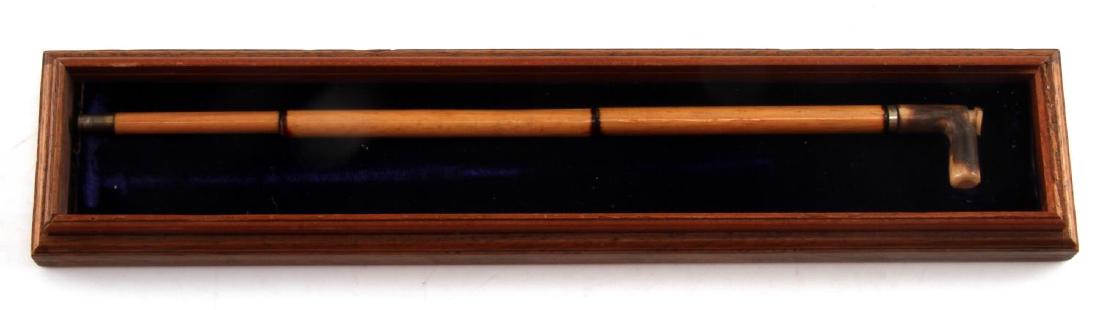 ANTIQUE MINIATURE BAMBOO CANE BLOW GUN: A miniaturized cane blowgun made from bamboo with an antler handle. Measures 9 inches in length overall. Has removable section on breech for loading, handle screws off, and the shaft is in three secti