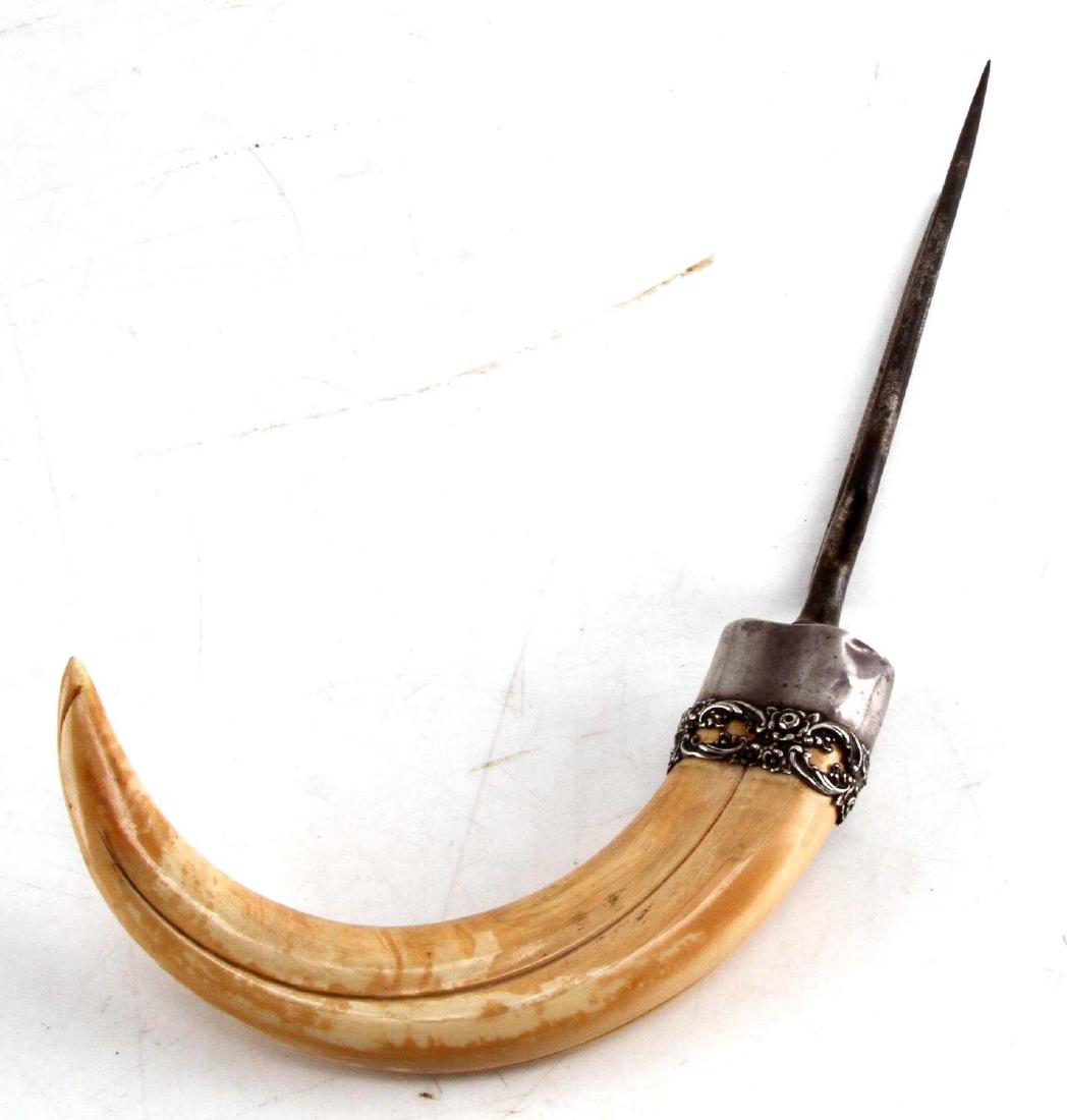 GERMAN BOAR TUSK SKEWER CAPPED IN STERLING SILVER: Tusk measures 10 1/2 inches, on the curve, capped in sterling silver and a 6 1/2 inch skewer marked Germany, with substantial use wear to skewer prongs.