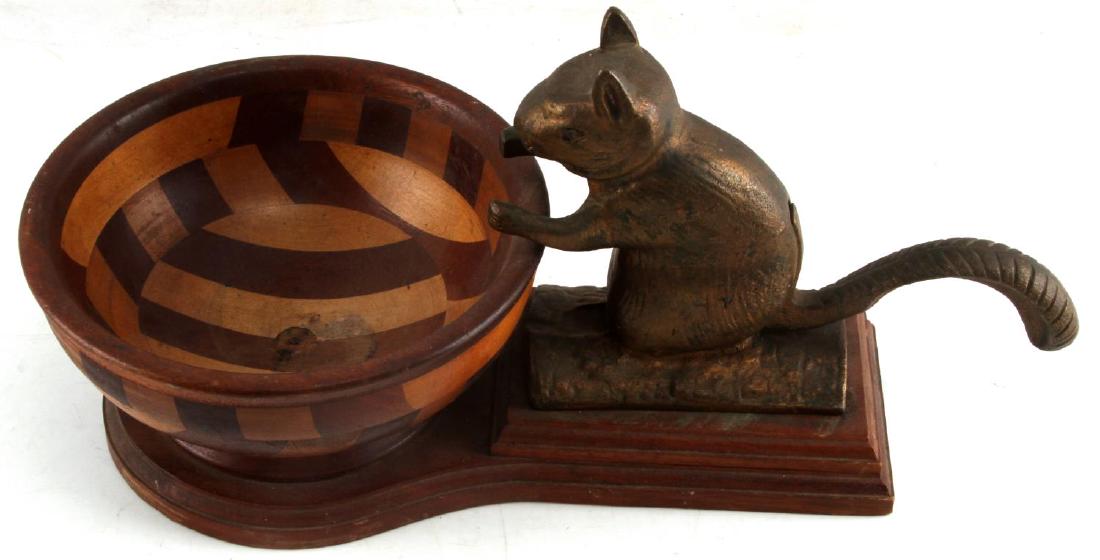 SQUIRREL NUTCRACKER WITH WOOD INLAY BOWL: The cast iron squirrel with coppery finish cracks the nut over a multi color wood inlay bowl . Measurements: 8x17x8 inches. Vintage with use wear.