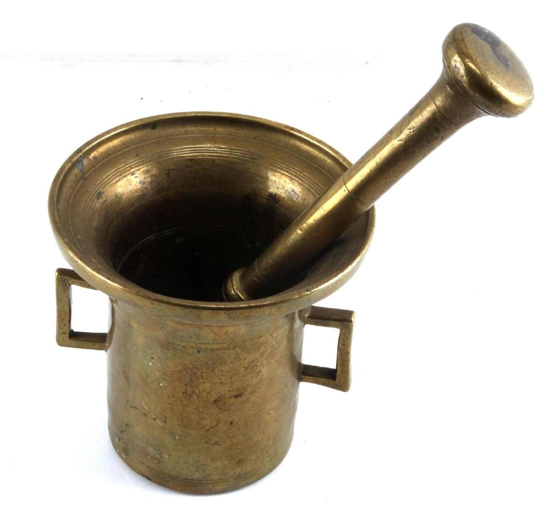 18TH CENTURY ANTIQUE BRONZE MORTAR AND PESTLE: Front marked 1761 height 6 inches, diameter 6 inches. Pestle is 10 3/4 inches long. Small indentations and use wear.