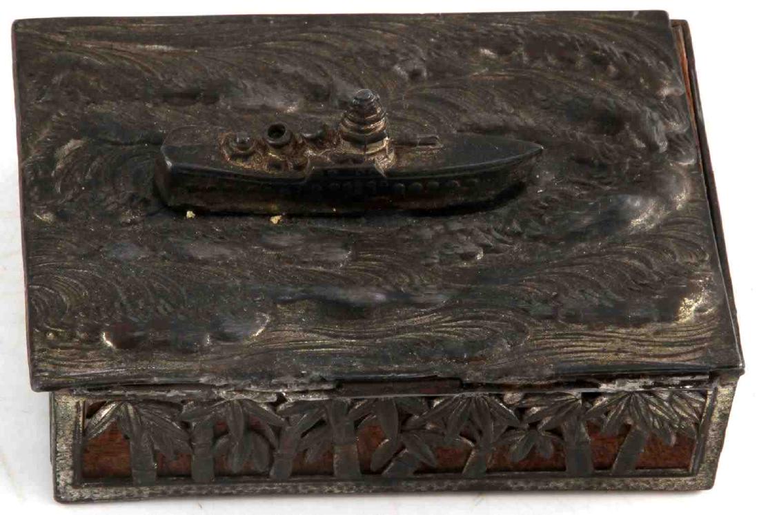 KOREAN WAR VETERAN BRING BACK NAVAL TRINKET BOX: Korean War Veteran Bring Back Naval Trinket Box made from wood overlayed with a metallic cage like cover which depicts palm fronds on the exterior and a Naval Destroyer on the high seas on top of the 