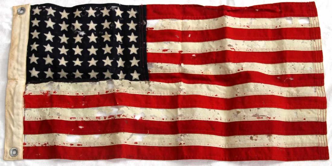 WWII 1944 DATE U.S BATTLE FLAG OF TATTERED RAYON: WWII Dated flag made of tattered rayon with the date "U.S NO 12 M1 44" visible still in black stencil on the white fabric spine of the rayon flag which measures 37 inches long by 15 inches in width. S