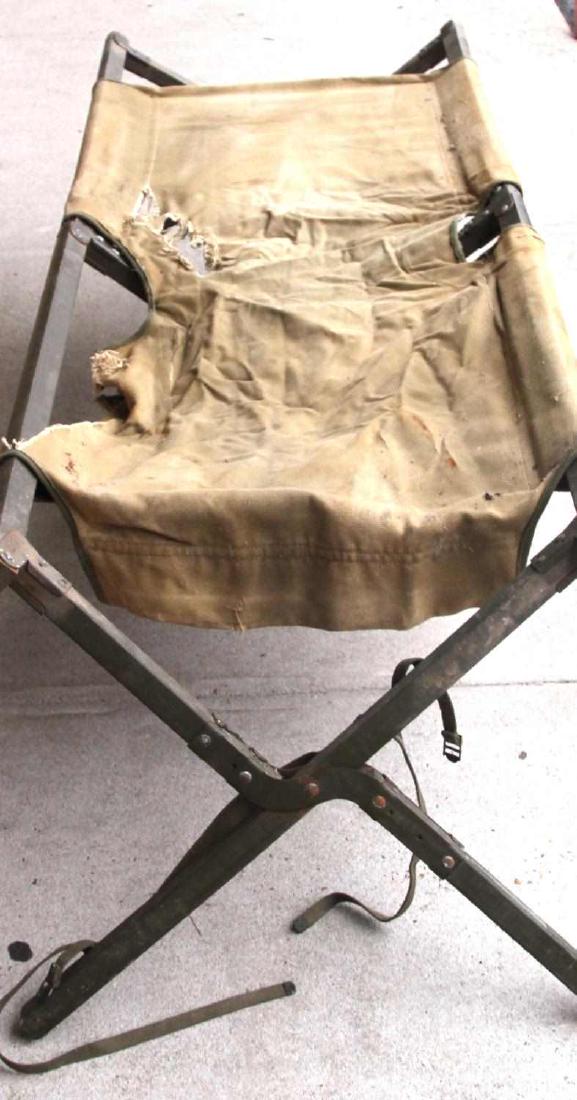 US ARMY POST WWII FOLDING WOOD FRAME STRETCHER: A wooden-frame folding US stretcher. Marked 'National Wood Company 1953'. In good condition, has some wear on the edges of the canvas.