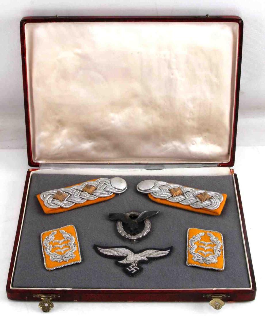 GERMAN WWII LUFTWAFFE DISPLAY SET PILOTS BADGE: German WWII Luftwaffe personal display set. Includes collar tabs, shoulder boards, pilots badge, and breast patch. Case measures 7 3/4" x 10 1/2" and shows a red exterior with grey wool interior. VG c