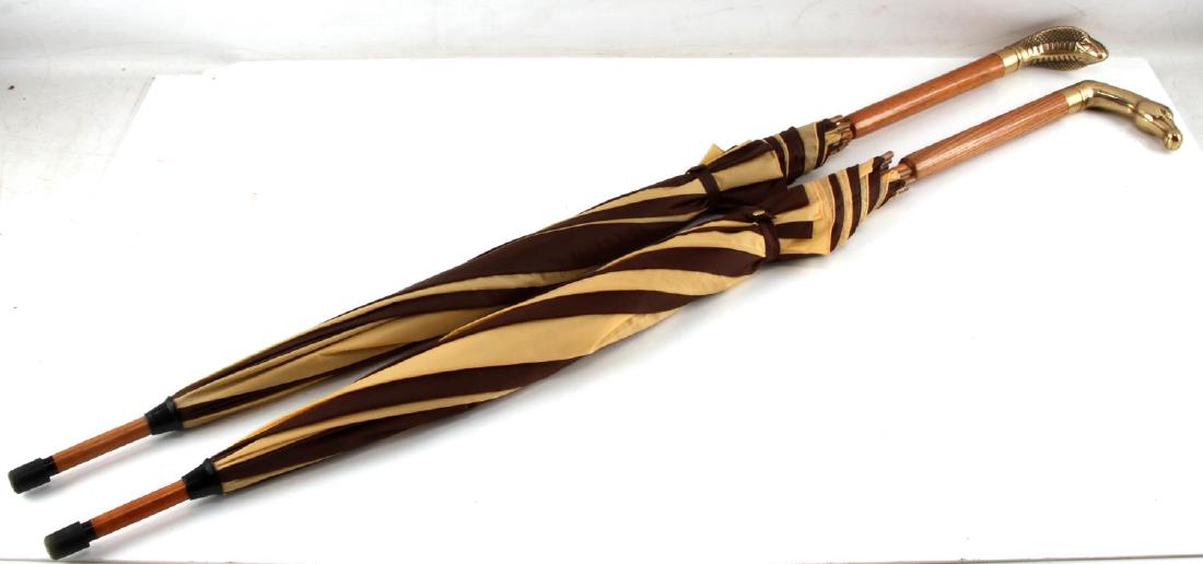 GENTLEMANS UMBRELLA W STILETTO KNIFE HANDLE LOT: Malacca wood cane with brass horse and cobra stiletto knife handles, and beech-wood frame. Stainless steel stiletto knife measures 5 1/2 inches and is in excellent condition.