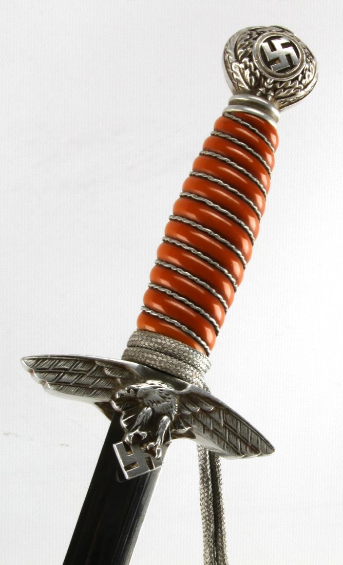 WWII GERMAN THIRD REICH 2ND MODEL LUFTWAFFE DAGGER: Officers dagger with scabbard, suspension rings, chain and portepee. Measures 16 1/2 inches in scabbard with a 10 inch blade. Blade is marked SMF Solingen under a hall mark of a king sitting with a sw