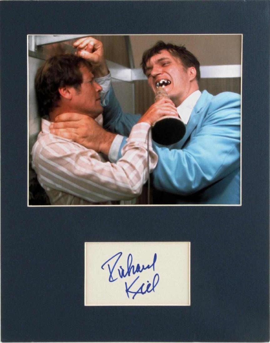 JAWS FROM JAMES BOND ACTOR RICHARD KIEL AUTOGRAPH: Matted photo of Jaws from the James bond movie signed by Richard Kiel. Measures 14 1/2 inches by 11 1/2 inches. In good ready to frame condition.