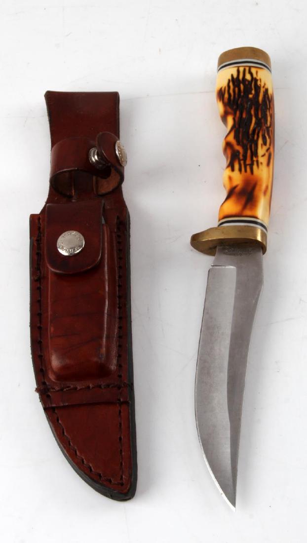 SCHRADE UNCLE HENRY KNIFE WITH LEATHER SHEATH: Model 153UH. Leather sheath with sharpening stone. Faux stag handle. Blade measures 5". VG condition.