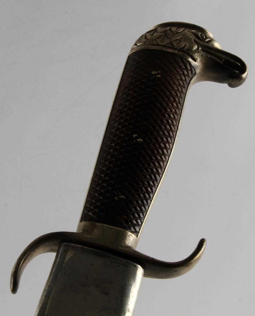 EAGLE HEAD POMMEL INFANTRY SWORD WITH SCABBARD: Pommel topped with white metal eagle head, wood crosshatched handle with worming, leather scabbard with white metal mouthpiece and ferrule has wear, cracking and a detached frog stud. Blade (serial no