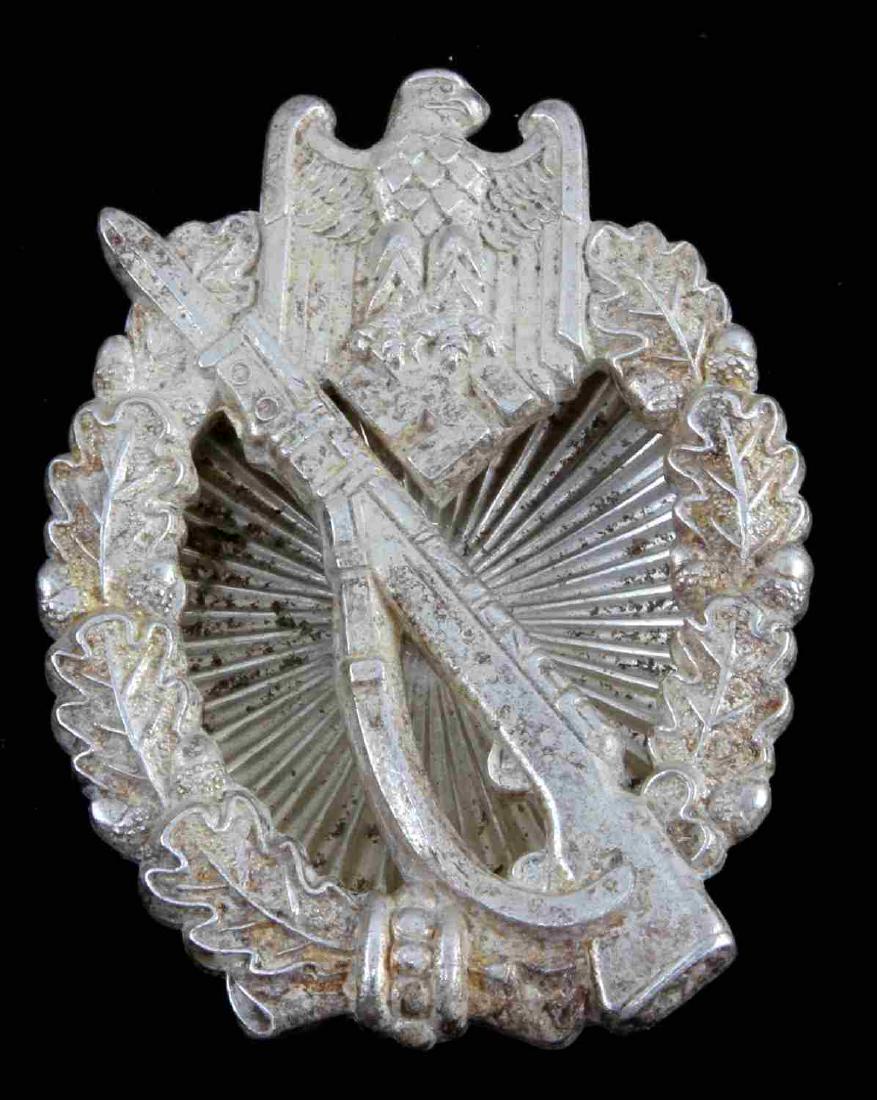 GERMAN WWII ARMY SILVER INFANTRY ASSAULT BADGE: Front shows K98 mauser rifle with eagle insignia above. Both surrounded by oval oak leaf wreath. Reverse is maker marked 'GWL'. Clam shell screw back variant. Solid nickel construction. Awarded for th