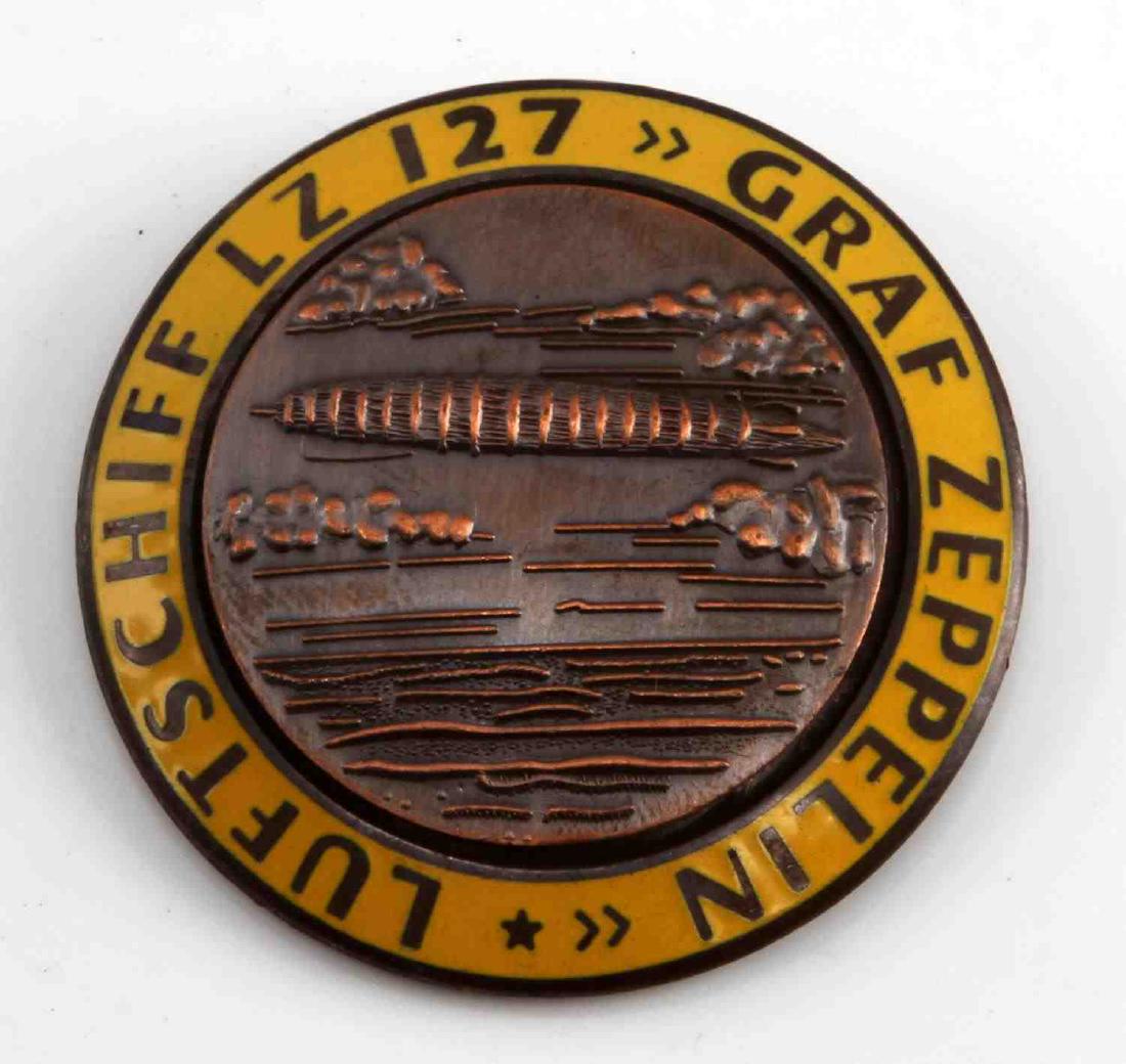 GERMAN WWII GRAF ZEPPELIN LZ 127 AIR SHIP BADGE: 1 3/4 inch diameter. Reverse maker marked "FLL". Thin, horizontal pin back. Two-piece copper and enamel construction . Unauthenticated. Sold "as is".