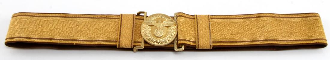 GERMAN WWII POLITICAL LEADER BROCADE BELT: Includes special PL belt buckle. Buckle is 2 inches in diameter and maker marked "RZM M4/24". Gold brocade belt measures 34 (L) x 1 15/16 (T) inches. Brown velvet backing. Includes both belt keepers. 