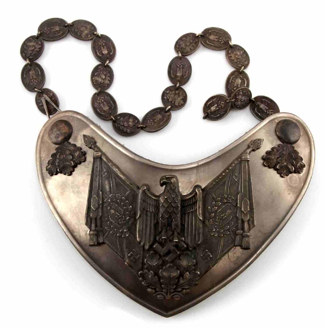 GERMAN WWII 3RD STANDARTE FLAG BEARER GORGET: Measures 7 inches wide by 5 inches tall. Back has 3 flat vertical prongs. One is marked "H AH". Aurich Dresden". Green wool present to back. Includes nickel neck chain with rotating German Army eagles