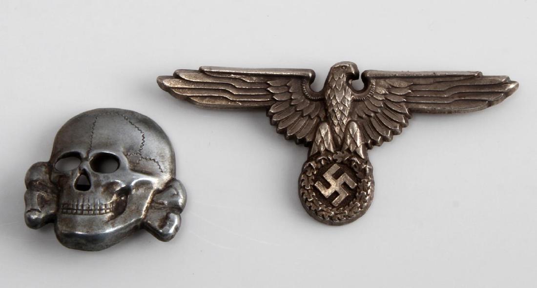 GERMAN WWII WAFFEN SS OFFICER CAP EAGLE & SKULL: Waffen SS officer's visor cap eagle & skull. Maker marked "RZM M1/24". Both have two flat prongs on back. Stamped silver plated nickel construction. Unauthenticated. Sold "as is".